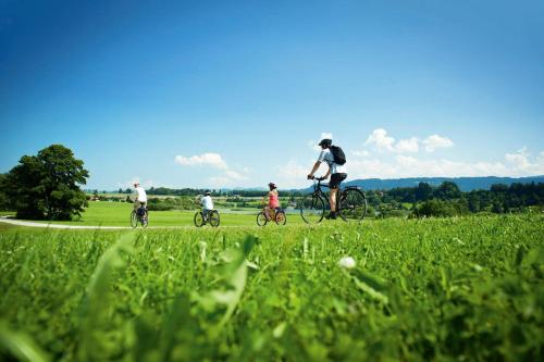 a group of people riding bikes in a field at Hotel Natur-Landhaus Krone in Maierhöfen