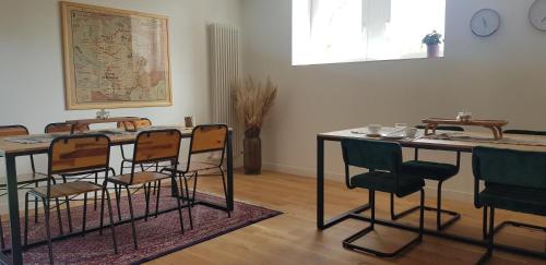 Habitación con mesa, sillas y mapa en la pared en La Passerelle, en Morlaix