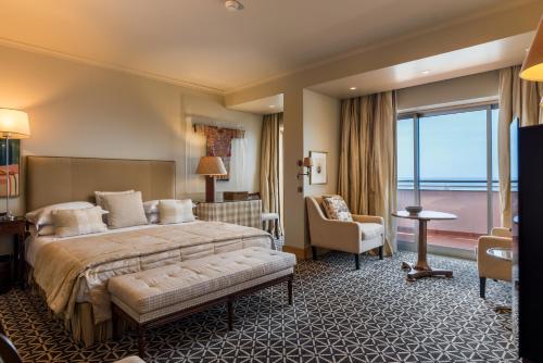 a hotel room with a bed and a large window at Royal Savoy - Ocean Resort - Savoy Signature in Funchal