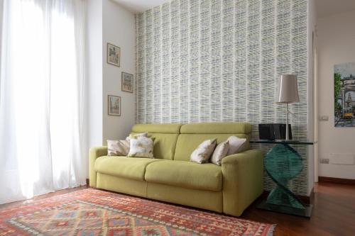 uma sala de estar com um sofá amarelo em frente a uma janela em Madeleine apartments - Residenza Belle Époque em Milão