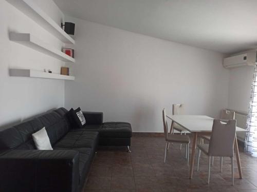 - un salon avec un canapé noir et une table dans l'établissement Open house, à Campofelice di Roccella
