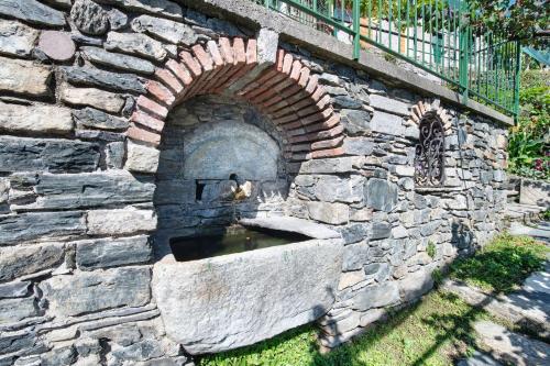 a stone wall with a water fountain in it at Crotto Palma in Dongo