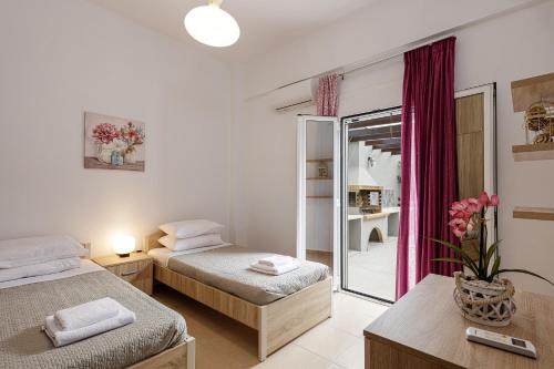 1 dormitorio con 2 camas y espejo en Villa Emily Rethymno, en Adelianos Kampos