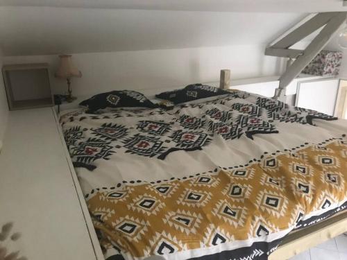 a bed with a blanket and pillows on it at Chez Beroy in Morlaas