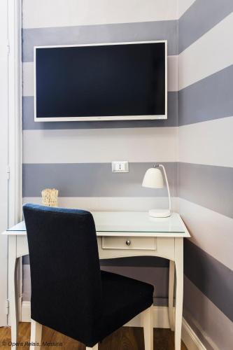 a desk with a chair and a tv on a wall at Opera Relais in Messina