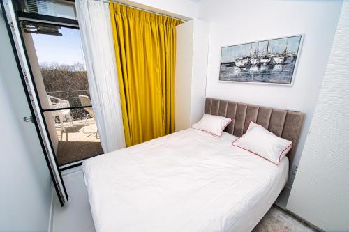 a bed with two pillows in a room with a window at Stef by Loft Oxygen in Jupiter