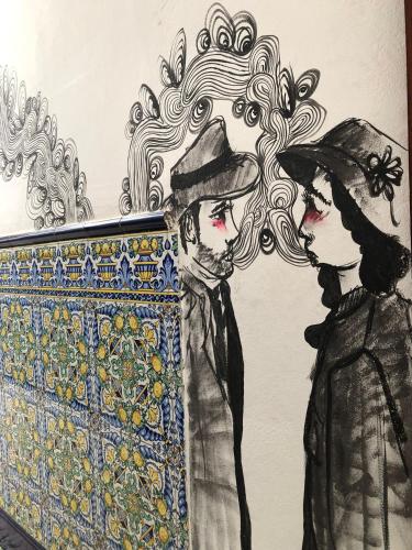 a drawing of two men standing next to a mosaic at Lua Lua Hostel Las Palmas in Las Palmas de Gran Canaria