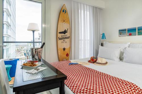 
a hotel room with a surfboard on the bed at Yam Hotel - an Atlas Boutique Hotel in Tel Aviv
