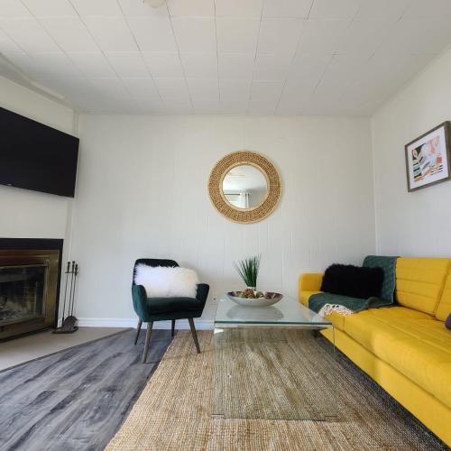 a living room with a yellow couch and a table at Muskoka Waterfront Retreat in Dwight