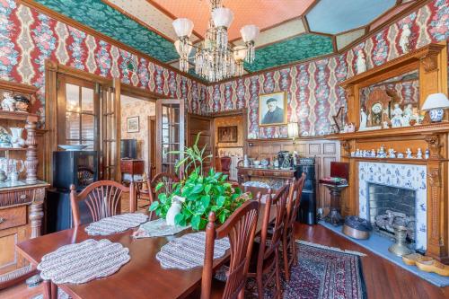 a dining room with a table and chairs and a fireplace at Captain Mey's Inn in Cape May