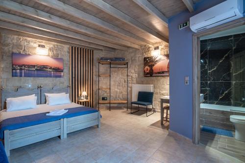 SkouloúfiaにあるAlexandros Villaのベッドルーム1室(ベッド1台付)、バスルーム(バスタブ付)が備わります。