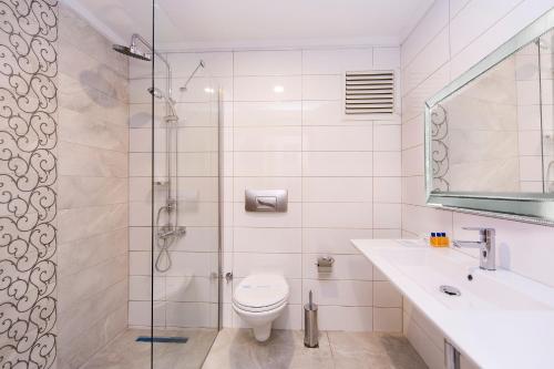 a bathroom with a shower and a toilet and a sink at Eftalia Holiday Village in Konaklı