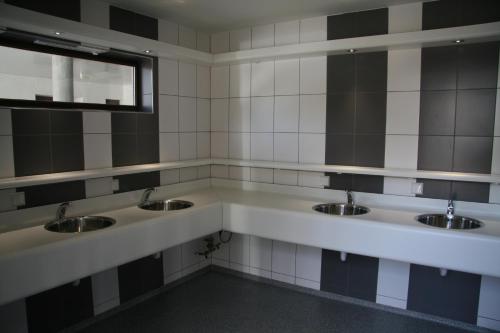 a public bathroom with three sinks and a mirror at Tiny rooms @ camping val d'Or in Enscherange