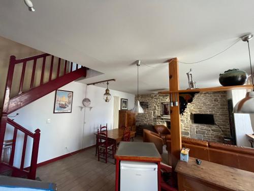 Una cocina y una sala de estar con chimenea de piedra. en Le Passage, en Concarneau