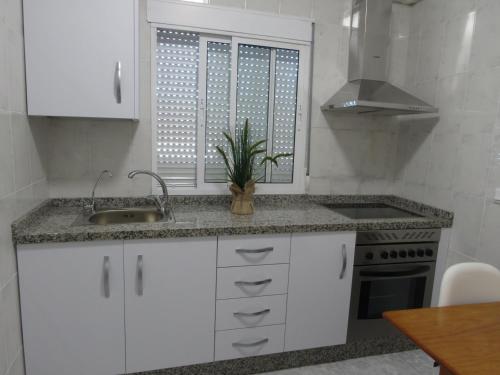 a kitchen with white cabinets and a sink at CASA TITO JOSE in Valle de Abdalagís