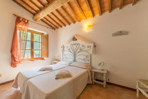 a bedroom with a white bed in a room at Borgo da Vinci in Volterra