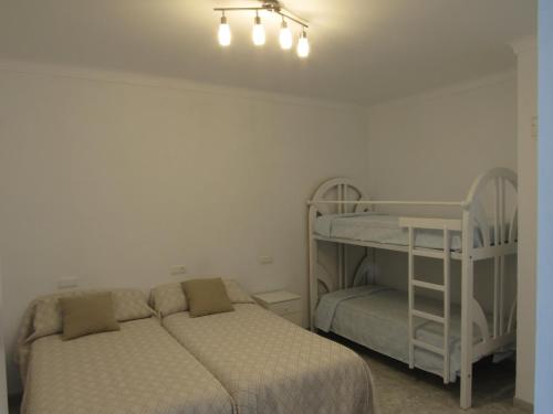 a bedroom with two beds and a bunk bed at CASA TITO JOSE in Valle de Abdalagís