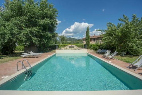 a swimming pool with lounge chairs in a yard at Borgo da Vinci in Volterra