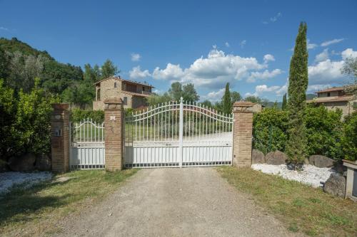a white fence with a gate in a driveway at Borgo da Vinci in Volterra