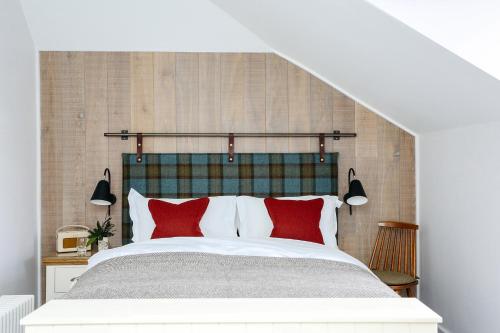 a bedroom with a large bed with red pillows at Pentonbridge Inn - Restaurant with Rooms in Carlisle