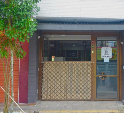 a door to a building with a sign on it at Studio Bangalô Belém Hospedagem in Belém