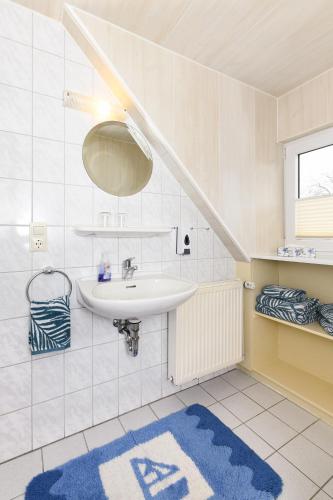 a bathroom with a sink and a blue rug at haus-sand-am-meer in Neuharlingersiel