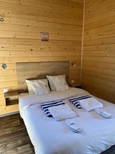 ein großes Bett mit zwei Handtüchern darüber in der Unterkunft Chalet avec spa, Au Bois Quartois in La Quarte