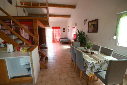 una sala da pranzo con tavolo e sedie di Loft avec mezzanine a Montagnac