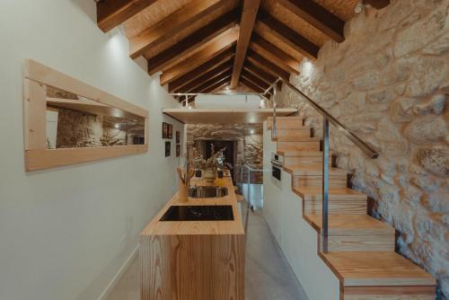 una cocina con encimeras de madera y una escalera con vigas de madera. en Maraxe 45, en Combarro