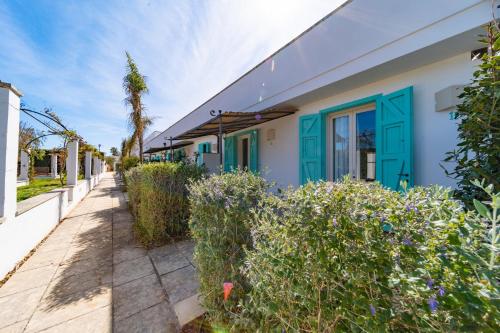 a house with a blue door and some bushes at Tenuta Centoporte in Otranto