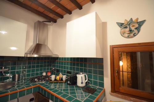 a kitchen with green tiled counters and a sink at La Divina Dimora Il Castello degli Spiriti Magni in Montepescali