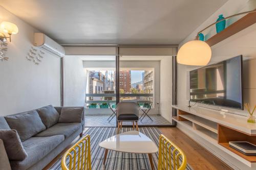 a living room with a couch and a tv at Apartment - El Golf - Costanera Center in Santiago