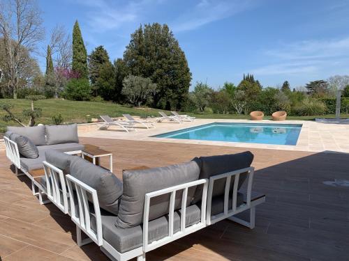 a pool with several lounge chairs and a swimming pool at La Parenthese Saint Donat in Aix-en-Provence