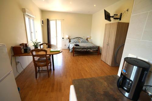 a living room with a table and a bed at Studio Indépendant Douceur Provençale in Montagnac