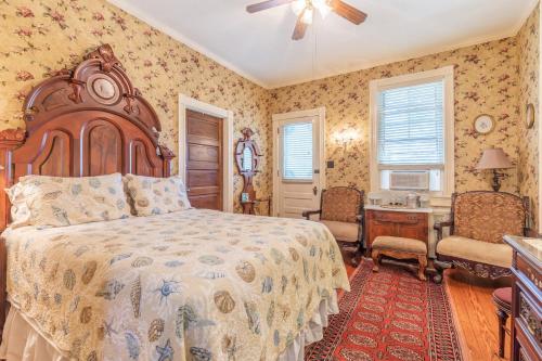 1 dormitorio con 1 cama, mesa y sillas en Captain Mey's Inn, en Cape May