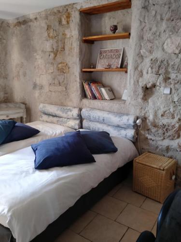 two beds with blue pillows in a room at Au coeur du Caylar in Le Caylar