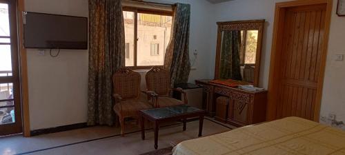 a bedroom with a bed and a table and a mirror at Luxury Palace Peshawar in Peshawar