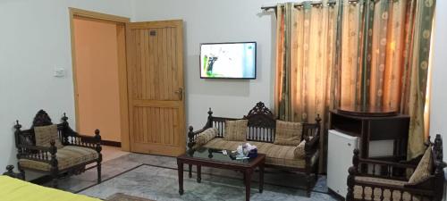 a living room with a couch and two chairs at Luxury Palace Peshawar in Peshawar
