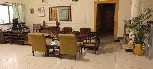a living room with a table and chairs at Luxury Palace Peshawar in Peshawar