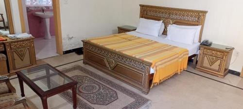 a bedroom with a large bed and a table at Luxury Palace Peshawar in Peshawar