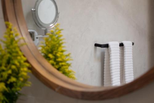 a mirror with a reflection of two white towels at Taller de Juan - Casa Hotel in San Cristóbal de Las Casas