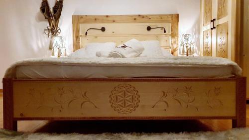 Una cama con sábanas blancas y almohadas. en Apartament Rykowisko en Zakopane