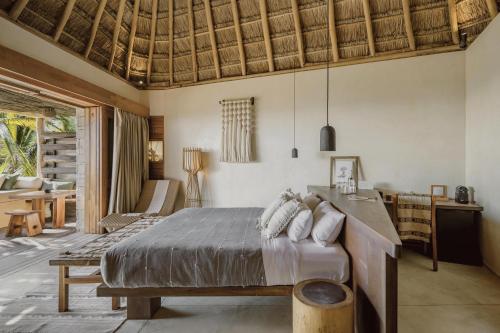 a bedroom with a bed and a living room at Hotel Ma'xanab Tulum in Tulum