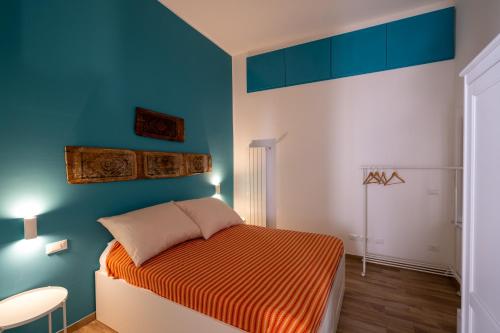 1 dormitorio con 1 cama naranja en una pared azul en Casa Queda, en Palermo