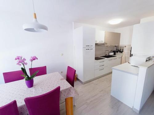 une cuisine et une salle à manger avec une table et des chaises violettes dans l'établissement Apartment Glavarić, à Omiš