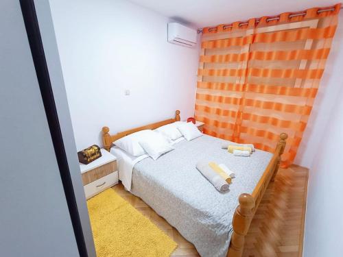- une chambre avec un lit et une tête de lit en bois dans l'établissement Apartment Glavarić, à Omiš