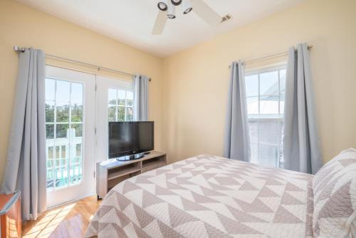 1 dormitorio con 1 cama y TV de pantalla plana en The Oysters Pearl on Harbor Island, en Oceanmarsh Subdivision