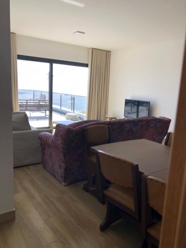 a living room with a couch and a table at Calheta Ocean View Family Apartment - Air Condition in Estreito da Calheta