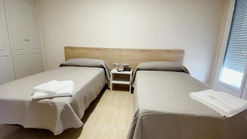 two beds sitting next to each other in a room at Hostal Restaurante Cuatro Caminos in Cubillos del Sil