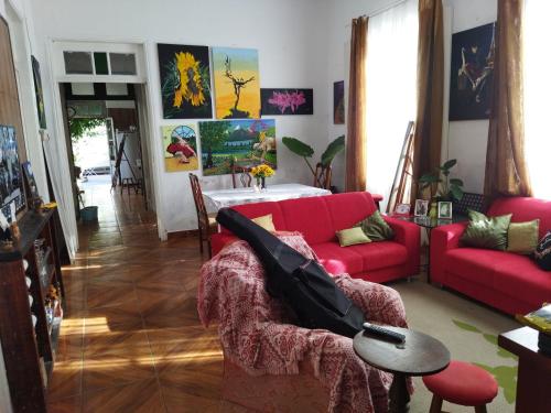 a living room with a red couch and a table at Hst Ateliê Marli Marques in Pelotas